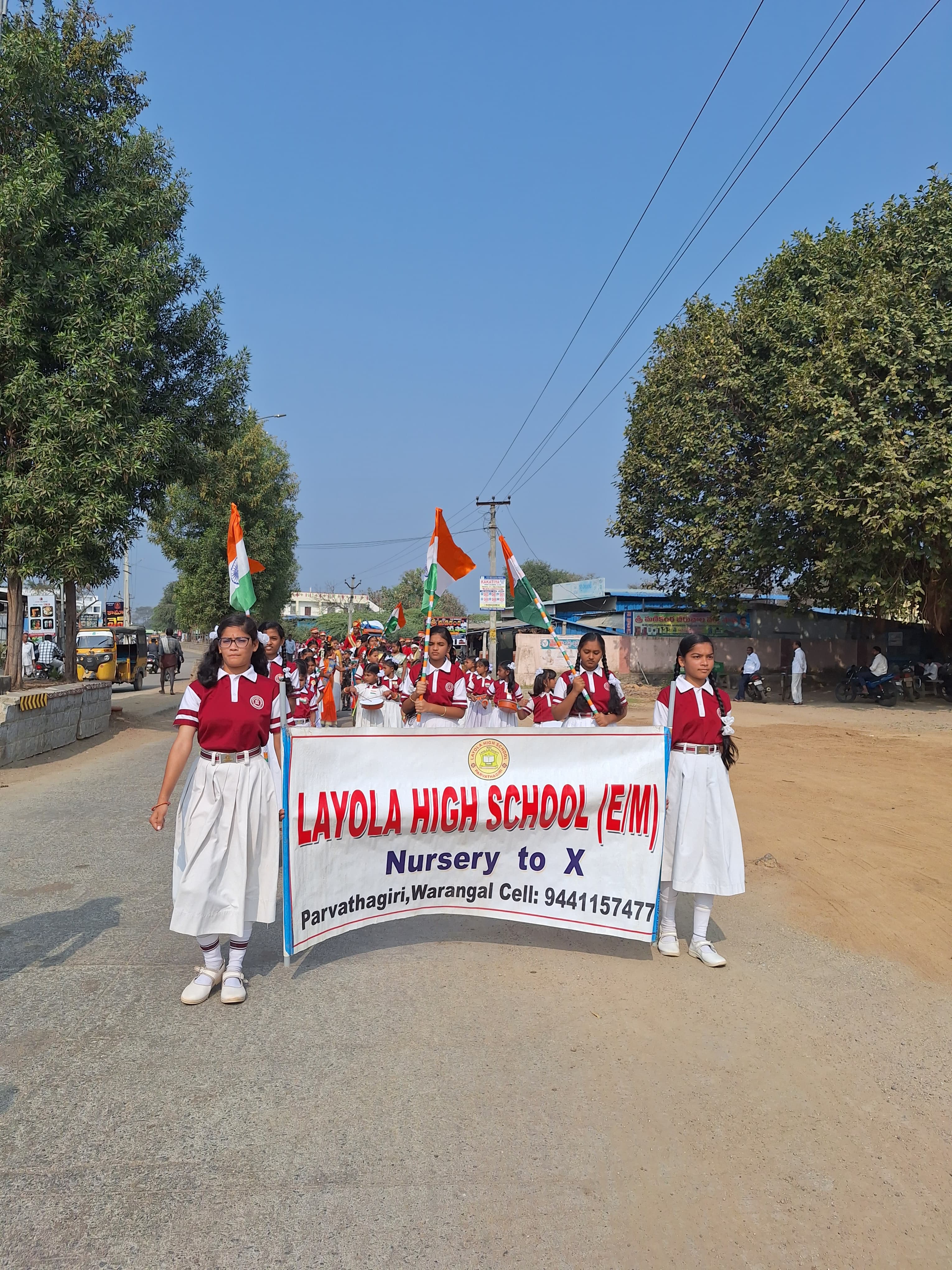 Students marching with a Layola High School banner on a public road